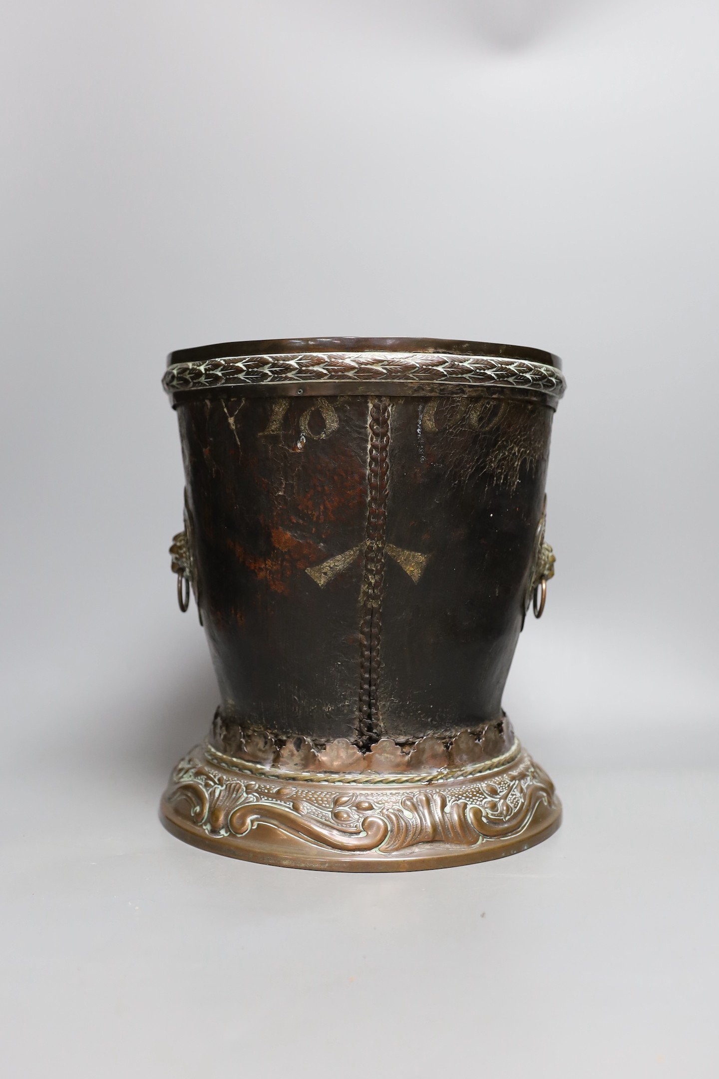 A George III leather fire bucket dated 1800, with later 19th century mounts, inscribed 'GR 1800 Pavilion' (cut down), 27cm tall